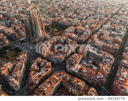 Aerial view of Barcelona City Skyline and Sagrada Familia Cathedral at sunset. Eixample residential famous urban grid. Cityscape with typical urban octagon blocks 99194774