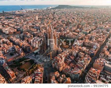 Aerial view of Barcelona City Skyline and Sagrada Familia Cathedral at sunset. Eixample residential famous urban grid. Cityscape with typical urban octagon blocks 99194775
