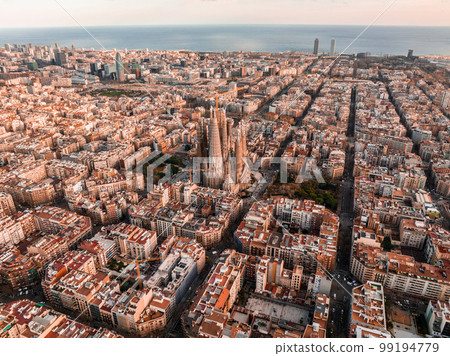 Aerial view of Barcelona City Skyline and Sagrada Familia Cathedral at sunset. Eixample residential famous urban grid. Cityscape with typical urban octagon blocks 99194779