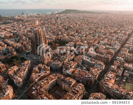 Aerial view of Barcelona City Skyline and Sagrada Familia Cathedral at sunset. Eixample residential famous urban grid. Cityscape with typical urban octagon blocks Aerial view of Barcelona City Skyline and Sagrada Familia Cathedral at sunset. Eixample residential famous urban grid. Cityscape with typical urban octagon blocks 99194853