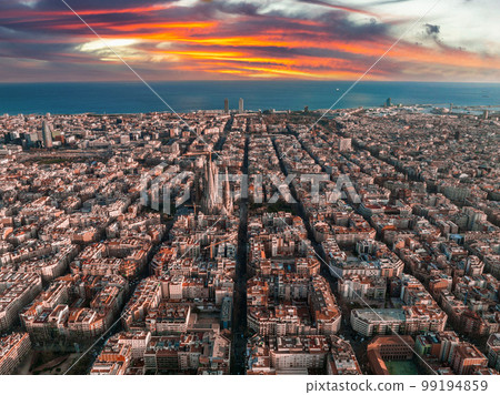 Aerial view of Barcelona City Skyline and Sagrada Familia Cathedral at sunset. Eixample residential famous urban grid. Cityscape with typical urban octagon blocks Aerial view of Barcelona City Skyline and Sagrada Familia Cathedral at sunset. Eixample residential famous urban grid. Cityscape with typical urban octagon blocks 99194859