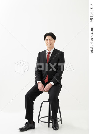 A businessman sitting in a chair A businessman sitting in a chair 99195109