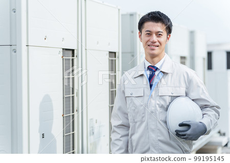 A male worker standing in front of the outdoor unit 99195145