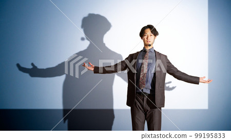 Young business person giving a speech with the screen in the background Young business person giving a speech with the screen in the background 99195833