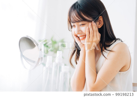 Smiling woman doing skin care 99198213
