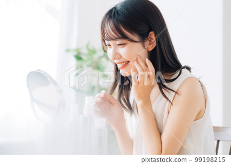 微笑的女人在鏡子裡檢查自己的皮膚 微笑的女人在鏡子裡檢查自己的皮膚 99198215