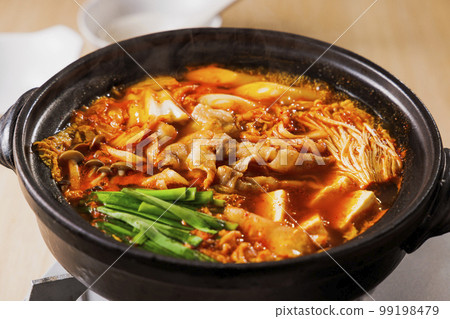 Kimchi hot pot with lots of ingredients in a black clay pot Kimchi hot pot with lots of ingredients in a black clay pot 99198479