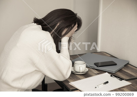 一個女人在她的辦公桌前抱著頭 麻煩 99200869