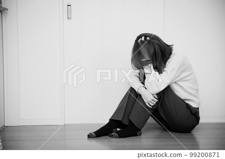 woman holding her head in the living room 99200871