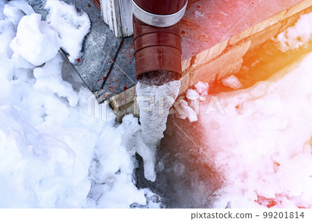 frozen water in downspout gutter of the roof drainage system with ice 99201814