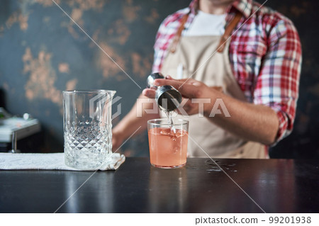 image of a bartender using a shaker to make a cocktail. image of a bartender using a shaker to make a cocktail. 99201938