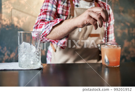 bartender mixing a cocktail at the bar. 99201952
