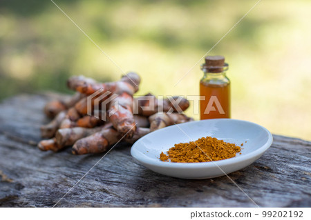 Turmeric, essential oil on wooden background. spa concept. 99202192