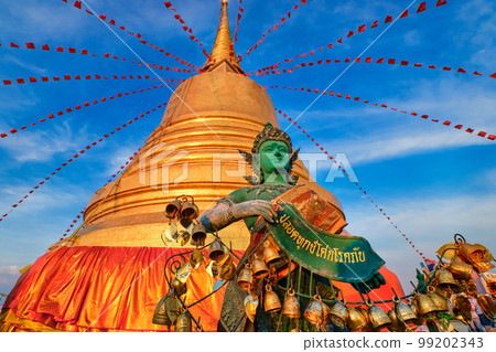 Thai angel by golden stupa in sunlight and blue sky in Buddhist temple. Thai angel by golden stupa in sunlight and blue sky in Buddhist temple. 99202343