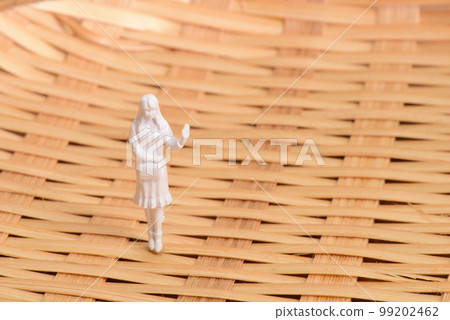Bamboo strip surface and miniature woman 99202462