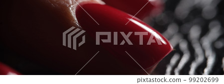 Stylish beautiful red nails on dark background 99202699