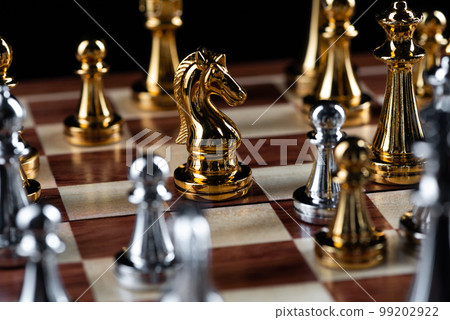 Gold and silver chess figures placed on chessboard Gold and silver chess figures placed on chessboard 99202922