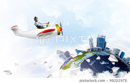 Man in aviator hat with goggles driving plane 99202978