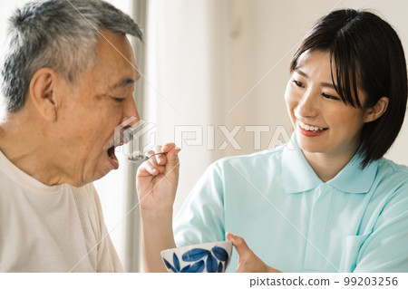 Caregiver feeding seniors Caregiver feeding seniors 99203256