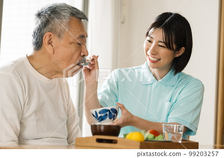 Caregiver feeding seniors Caregiver feeding seniors 99203257