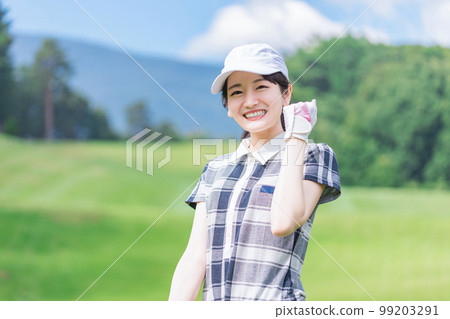 A golfer woman wearing golf wear playing golf on a golf course (guts pose, looking at camera) A golfer woman wearing golf wear playing golf on a golf course (guts pose, looking at camera) 99203291