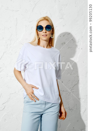 Cute woman posing in blue jeans and white shirt Cute woman posing in blue jeans and white shirt 99205130