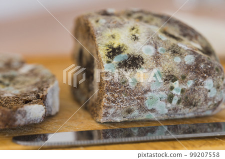 Moldy bread on a cutting board. Close-up view. Selective focus. Moldy bread on a cutting board. Close-up view. Selective focus. 99207558
