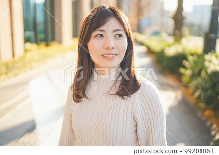 Woman smiling outdoors in winter 99208061