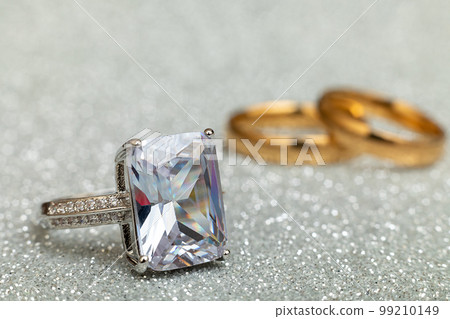 Will you marry me. Engagement ring and two wedding rings on silver glitter background. Engagement marriage proposal wedding concept. St. Valentine's Day postcard. Banner on valentines day. Copy space 99210149