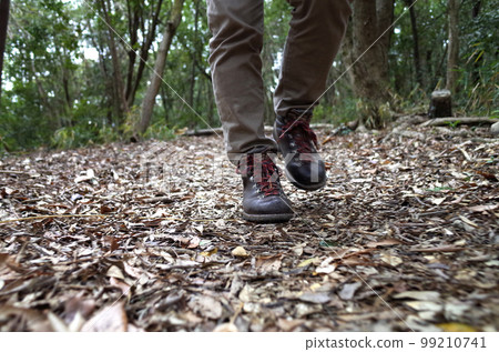 Climber's feet walking on the mountain 99210741