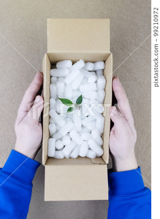 Eco package of parcels and biodegradable filler. Box is filled with a filler that does not harm the environment. Delivery of goods, parcels, delivery service, nature protection.  Recycling 99210972