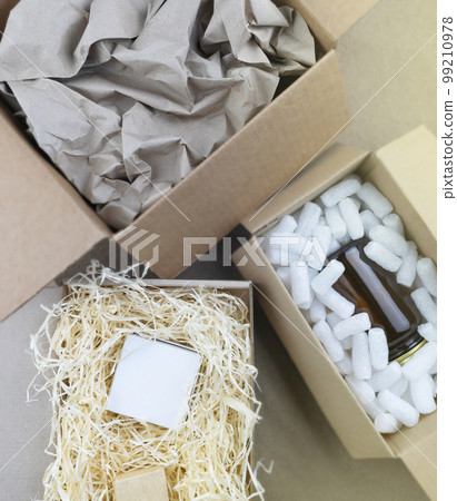 Eco package of parcels and biodegradable filler. Box is filled with a filler that does not harm the environment. Delivery of goods, parcels, delivery service, nature protection.  Recycling 99210978