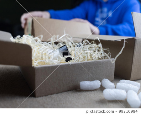 Eco package of parcels and biodegradable filler. Box is filled with a filler that does not harm the environment. Delivery of goods, parcels, delivery service, nature protection.  Recycling 99210984