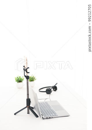 一張帶筆記本電腦、智能手機和耳機的白色桌子，用於直播 99212705