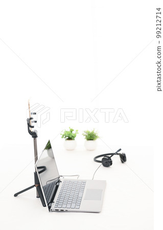 A white table with a laptop, smartphone and headphones for live streaming A white table with a laptop, smartphone and headphones for live streaming 99212714