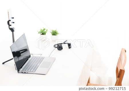 A white table with a laptop, smartphone and headphones for live streaming A white table with a laptop, smartphone and headphones for live streaming 99212715
