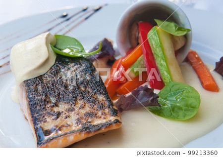 Delicious plate of grilled salmon with pepper garnish Delicious plate of grilled salmon with pepper garnish 99213360