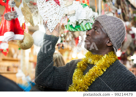 Man selecting festive Christmas decoration 99214479