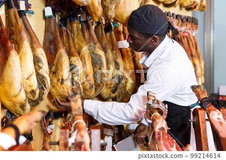 Active shop owner checking quality of jamon Active shop owner checking quality of jamon 99214614