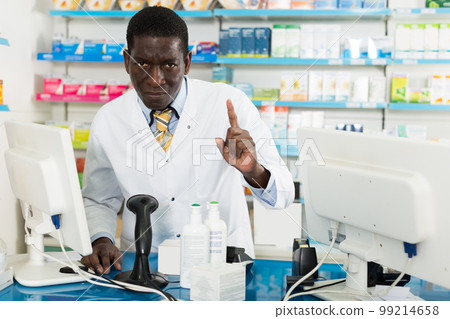 male pharmacist drawing attention of clients male pharmacist drawing attention of clients 99214658