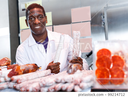 Seller offering delectable meat products in butcher shop 99214712