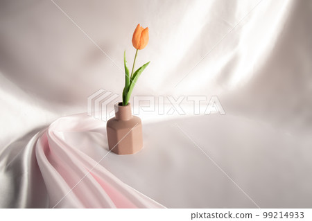 Orange tulips on a brown flower base 99214933