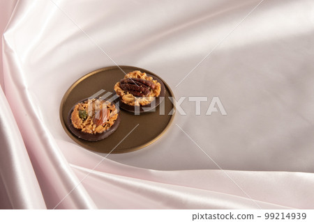 粉紅色背景中放在金色托盤上的巧克力佛羅倫薩 99214939