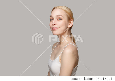 Pretty blonde woman with clean face smiling isolated on grey background. Beauty, cosmetics, skincare 99215001