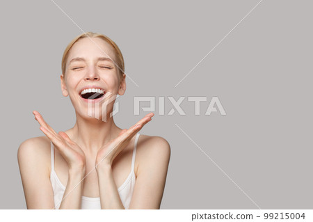 Portrait of beautiful emotional surprised young woman with opened mouth. Positive facial expression 99215004