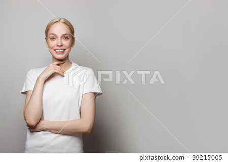 Attractive excited young woman wearing white t-shirt standing isolated Attractive excited young woman wearing white t-shirt standing isolated 99215005
