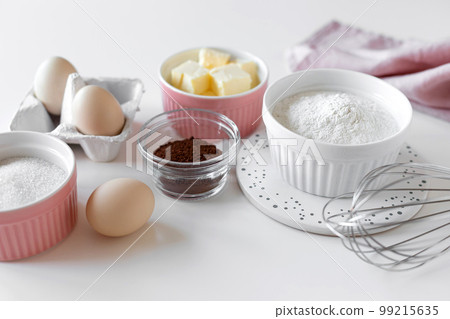 ingredients for baking chocolate cake on white table with kitchen utensils. closeup ingredients for baking chocolate cake on white table with kitchen utensils. closeup 99215635