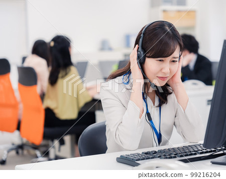 A woman at the customer center who is tired from answering the phone A woman at the customer center who is tired from answering the phone 99216204