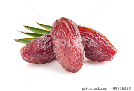 Dates fruit with leaves in closeup on white background Dates fruit with leaves in closeup on white background 99216228