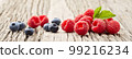 Raspberry and blueberry on old wooden background 99216234